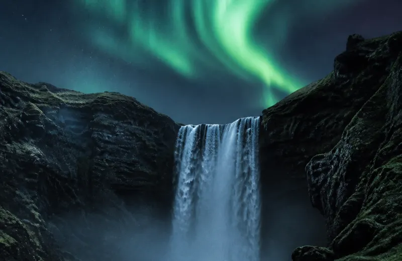 Icelandic waterfall beneath northern lights